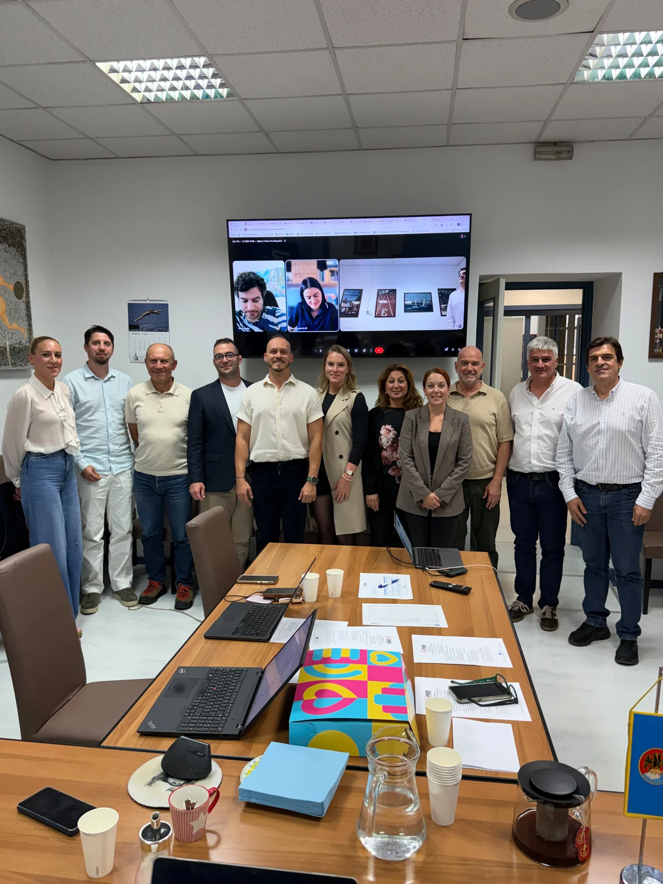 B-FREE partners gathered for a group photograph in the Rijeka meeting room, with online participants visible on the screen behind them.