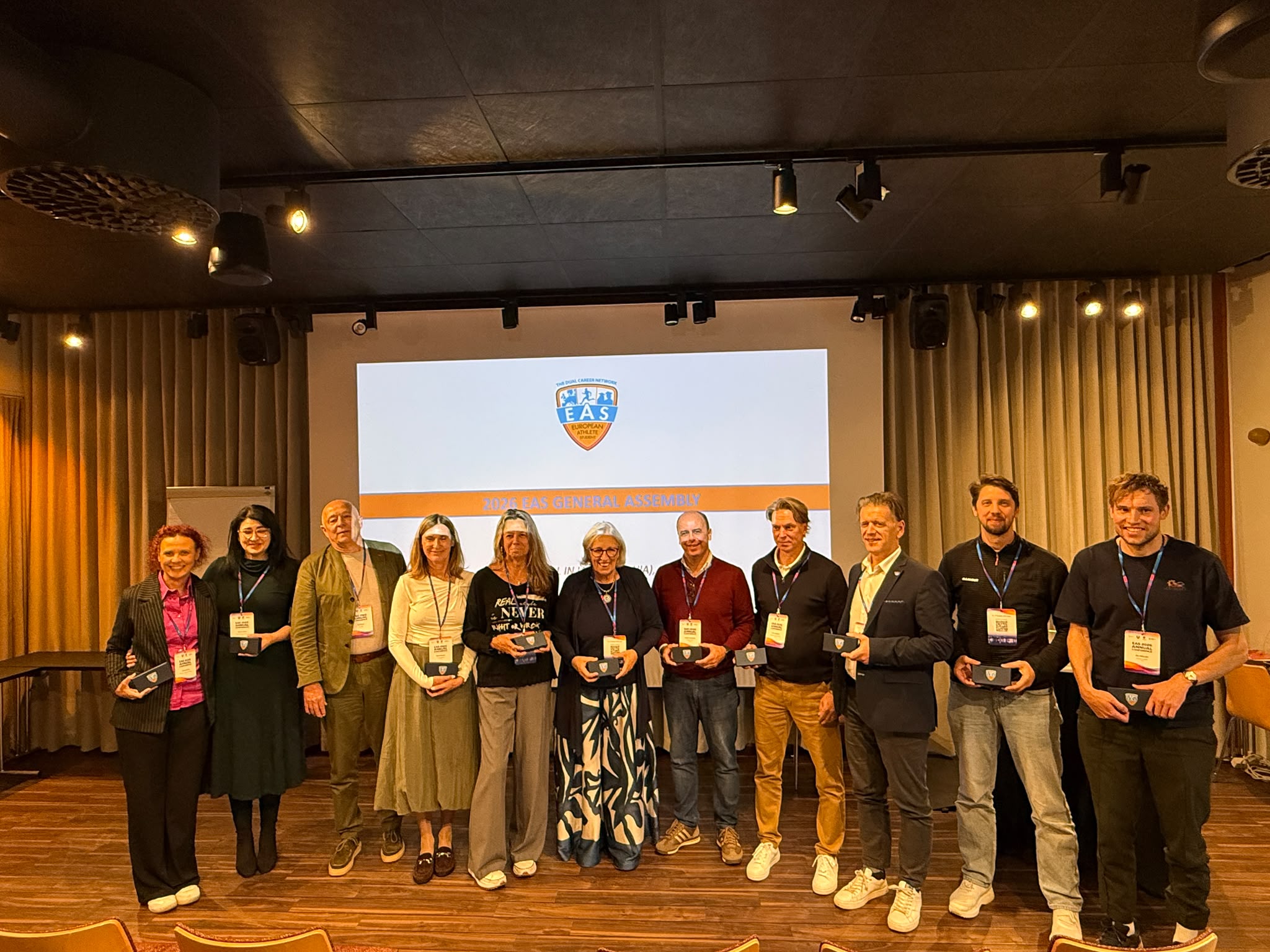 Group photograph at the 2026 EAS General Assembly in Oulu, Finland, with participants standing in front of the assembly presentation.