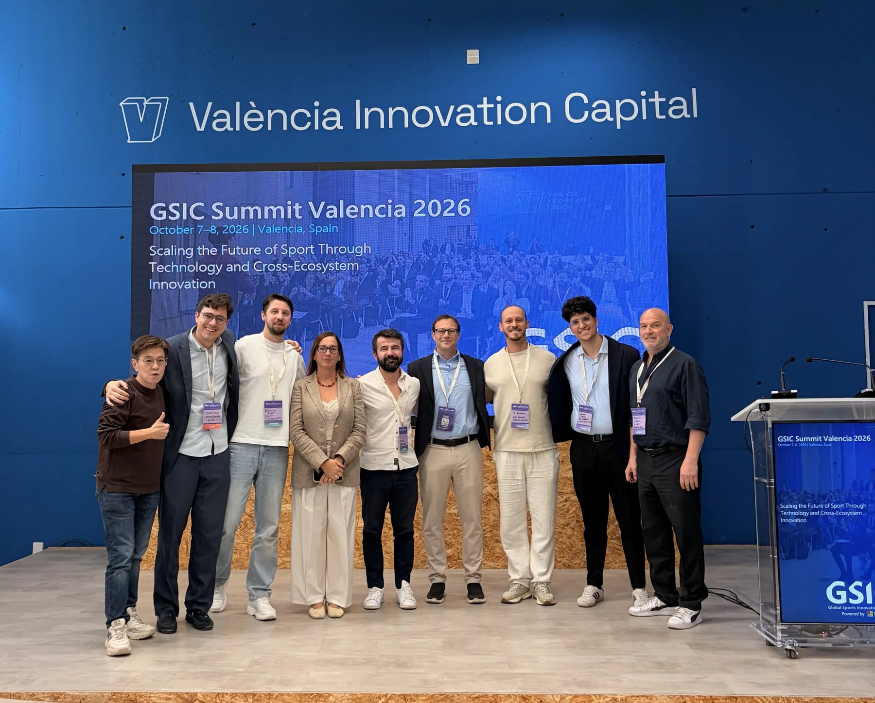 A group photograph of participants and facilitators on the Valencia Innovation Capital stage.